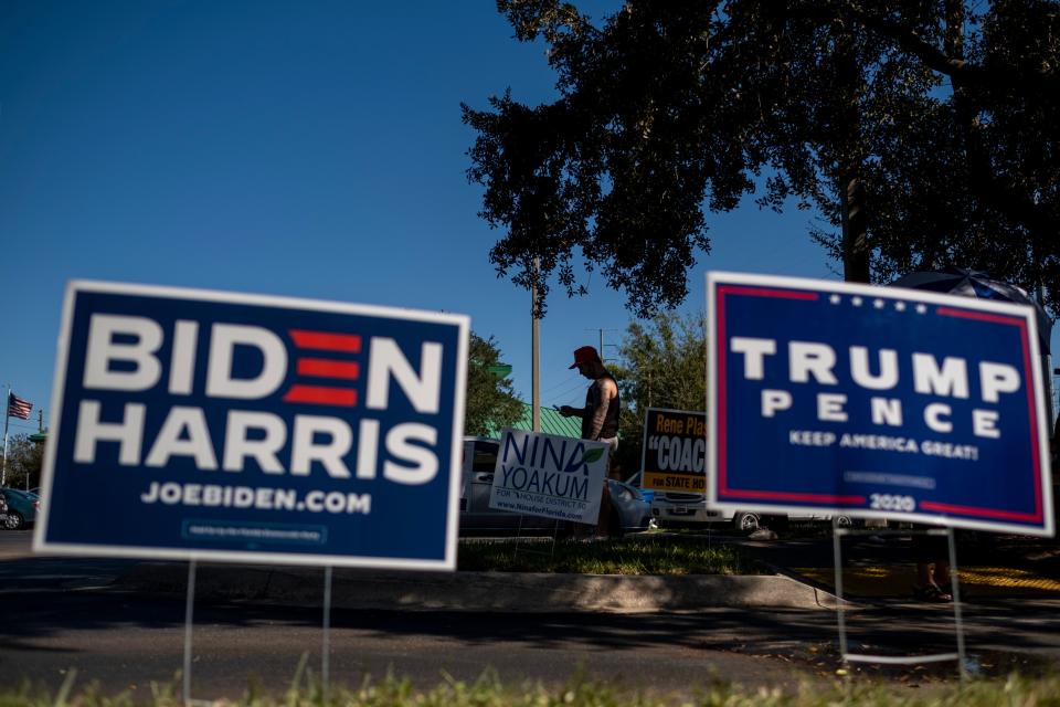 Biden and Trump campaign signs are displayed as voters line-up to cast their ballots during early voting at the Alafaya Branch Library in Orlando, Florida, on October 30, 2020. - Trump and Biden are focusing their greatest efforts on traditional battlegrounds that will decide the election -- such as Florida, where both campaigned this week. (Photo by Ricardo ARDUENGO / AFP) (Photo by RICARDO ARDUENGO/AFP via Getty Images)