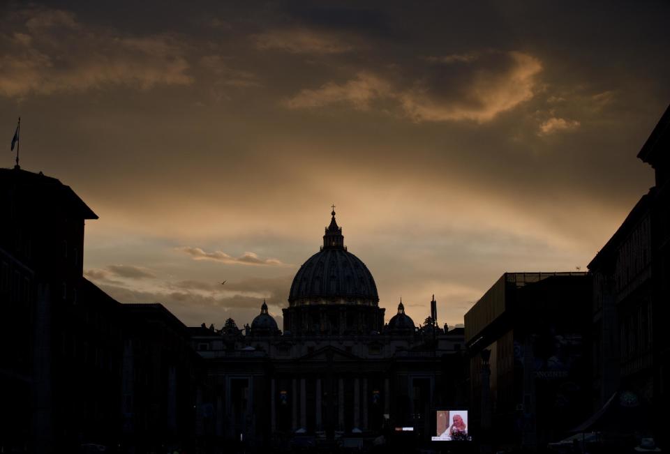 A large screen for public display shows Pope John Paul II after sunset outside St. Peter's Square at the Vatican, Saturday, April 26, 2014. Pilgrims and tourists streamed into Rome on Saturday to participate in the ceremony in St. Peter's Square that will see two popes, John XXIII and John Paul II, be proclaimed saints. (AP Photo/Vadim Ghirda)