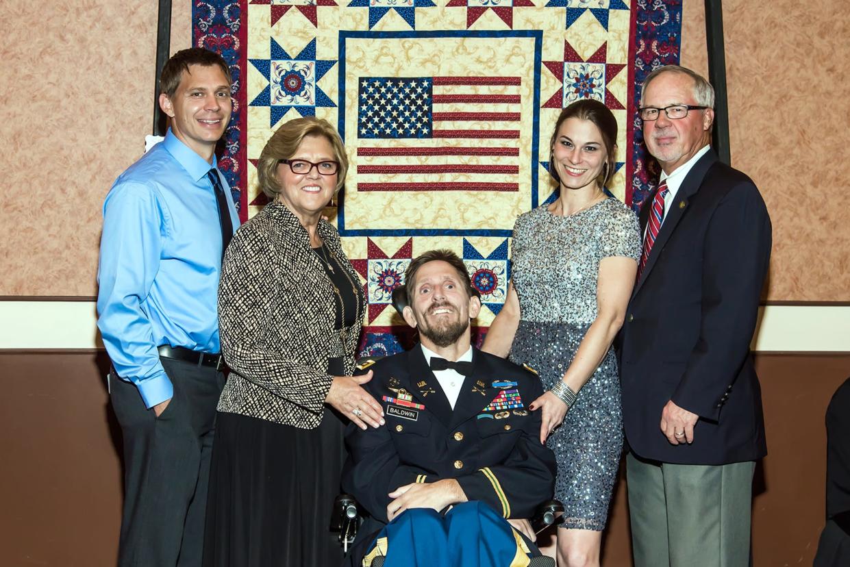 U.S. Army Special Forces Maj. Darren Baldwin is pictured in a 2017  photo taken during the Green Beret Foundation's gala in Cincinnati. With him are (from left) his twin brother, Mark Baldwin; his mother, Fran Wesseling; his wife, Bianca Baldwin; and his stepfather, Jim Wesseling. Darren Baldwin died Dec. 23, 2021, at age 46 from injuries he had sustained in Iraq in 2005.