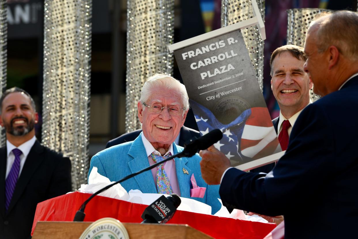 Mayor Joseph Petty presents to Frank Carroll a banner from the original dedication of the Francis R. Carroll Plaza from 2008 during the Wednesday-evening rededication. In rear, facing, is Troy Siebels, president and CEO of The Hanover Theatre.