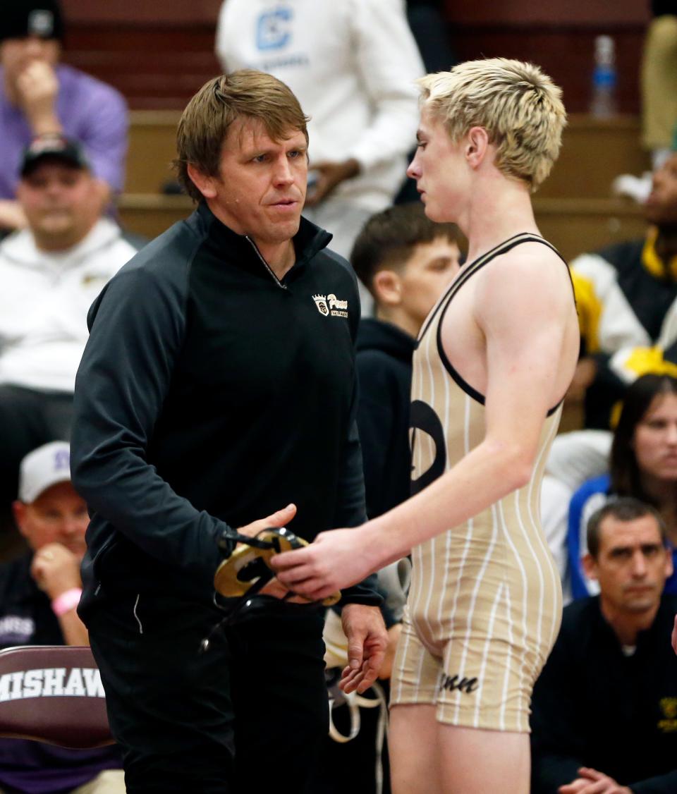 Penn wrestling head coach Brad Harper, left, talks with Kingsmen freshman Brady Harper following the 113-pound championship match at the Al Smith Classic Wrestling Invitational Saturday, Dec. 30, 2023, at Mishawaka High School.