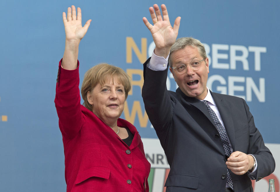 File - In this May 9, 2012 file picture German Chancellor Angela Merkel, left, waves to the crowd as she attends an election campaign rally together with Norbert Roettgen, right, top candidate of the Christian Democratic Union party CDU for the North Rhine-Westphalia federal state elections in Gelsenkirchen, Germany. Germany’s most populous state holds an election Sunday May 13, 2012 , with polls pointing to likely re-election for a center-left regional government that Chancellor Angela Merkel has sought to label as irresponsibly spendthrift. About 13.2 million people are eligible to vote for the state legislature in North Rhine-Westphalia in western Germany, which includes Cologne, Duesseldorf and the industrial Ruhr region. (AP Photo/Martin Meissner,File)