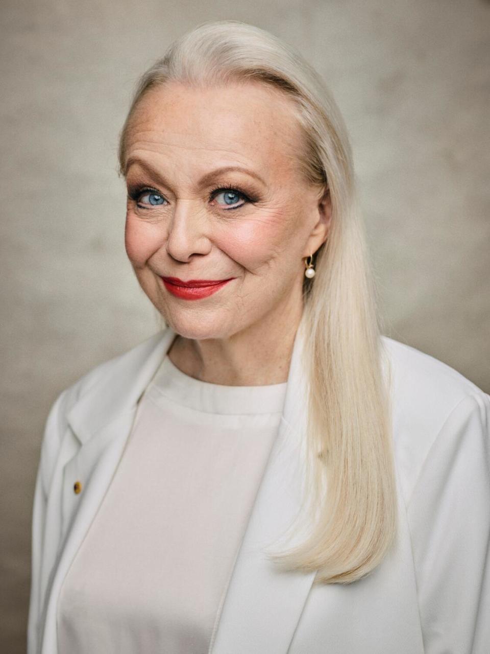 A woman in a white suit jacket