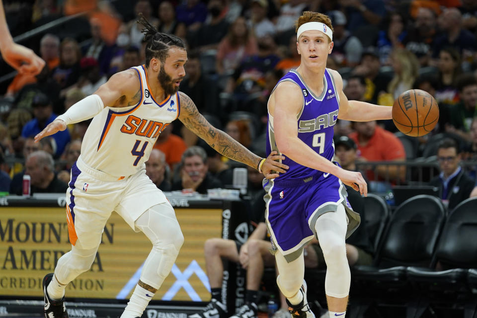 Sacramento Kings guard Kevin Huerter (9) drives as Phoenix Suns guard Duane Washington Jr. (4) defends during the first half of an NBA preseason basketball game, Wednesday, Oct. 12, 2022, in Phoenix. (AP Photo/Matt York)