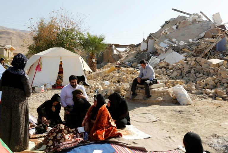 Iranians sitting next to the rubble of their homes two days after a 7.3-magnitude earthquake struck the Kouik village in in Iran's western Kermanshah province, killing hundreds and injuring thousands