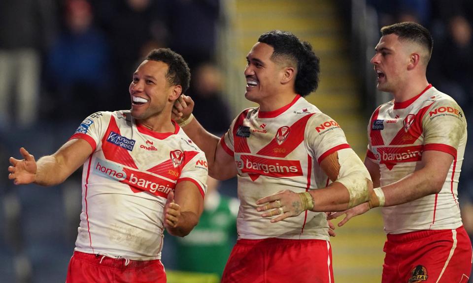 <span>Moses Mbye (left) celebrates scoring St Helens’ third try with teammates Sione Mata'utia (centre) and Lewis Dodd.</span><span>Photograph: Martin Rickett/PA</span>