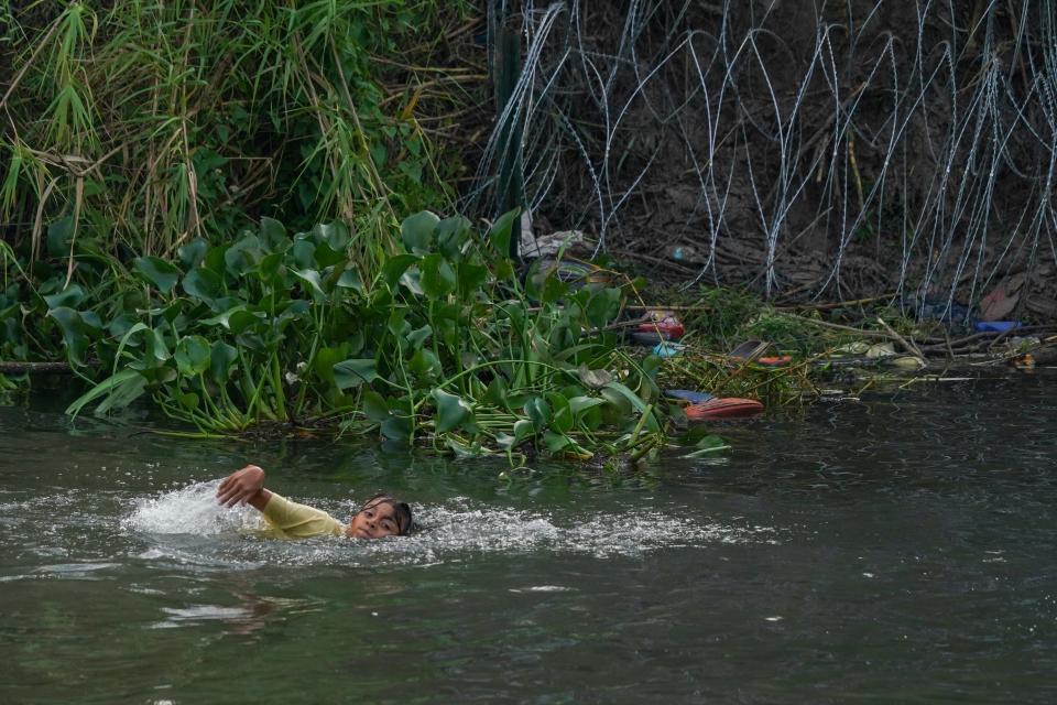 A young migrant swims across the Rio Grande to the U.S. from Matamoros, Mexico, on Wednesday. The U.S on Thursday will begin denying asylum to migrants who show up at the U.S.-Mexico border without first applying online or seeking protection in a country they passed through, according to a new rule released Wednesday.