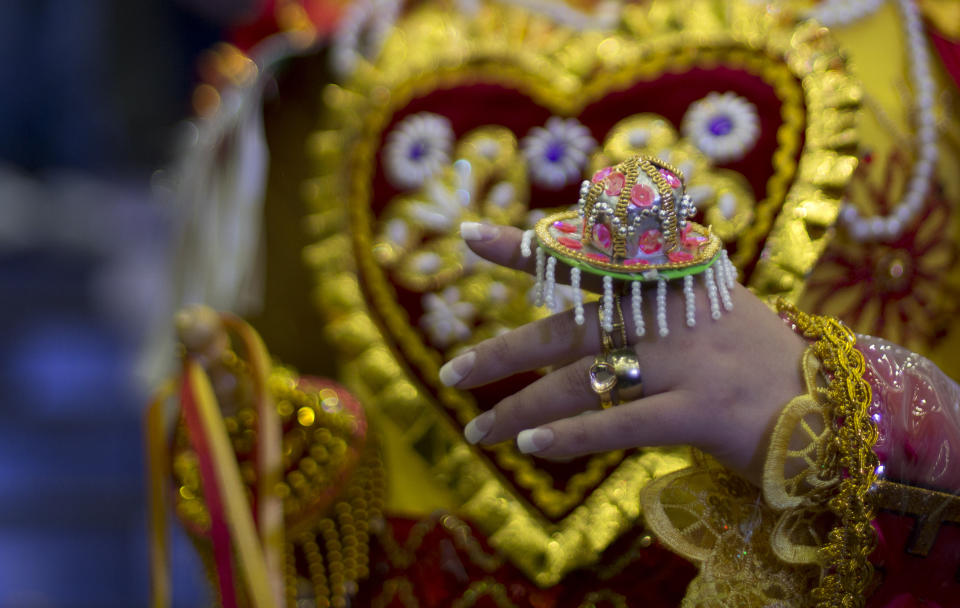 A contestant wears a ring hat as she competes in the Queen of Great Power contest, in La Paz, Bolivia, Friday, May 24, 2019. The largest religious festival in the Andes choses its queen in a tight contest to head the Festival of the Lord Jesus of the Great Power, mobilizing thousands of dancers and more than 4,000 musicians into the streets of La Paz. (AP Photo/Juan Karita)