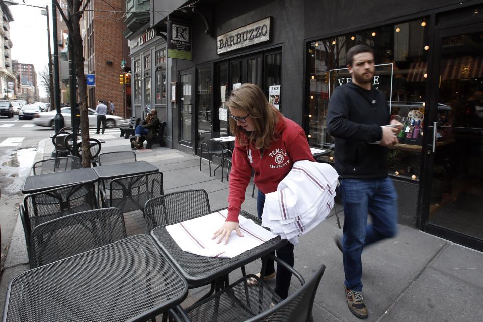 In this Tuesday, April 1, 2014 photo, workers prepare an outside seating area at Barbuzzo, a Mediterranean kitchen and bar, along 13th Street in Philadelphia. Tourism officials will tell you the restaurant-rich area in the heart of downtown is called Midtown Village, but that moniker hasn't entirely caught on with locals. Philadelphia food lovers just know 13th Street as a vibrant area chock full of great eateries and wine bars. (AP Photo/Matt Slocum)