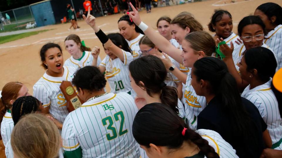 Bryan Station’s Michelle Moore, holding trophy, and the rest of the Bryan Station softball team celebrated the school’s first 42nd District softball championship after defeating Frederick Douglass.