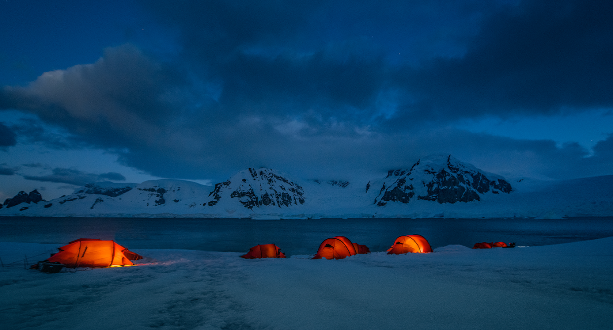 Tents lit up on Antarctica at night.