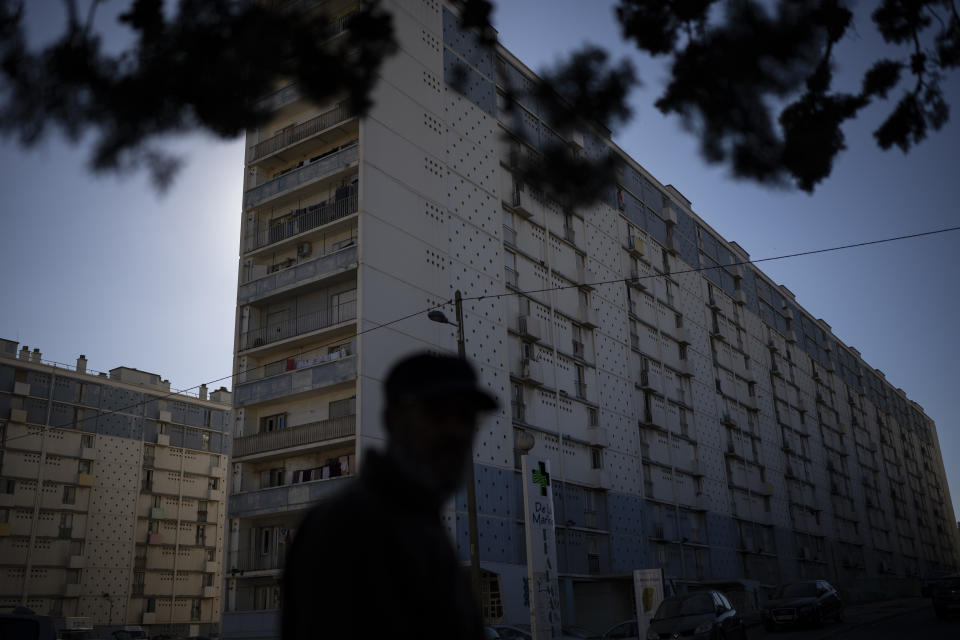 The cite de la Marine Bleue is pictured from outside Yaizid Bendaif's garden in Marseille, southern France, Tuesday, Oct. 26, 2021. Urban gardens are sprouting hope in drug- and violence-plagued neighborhoods of Marseille. From publicly funded city-wide initiatives to residents taking it upon themselves to start cultivating the land around them, urban farming is changing the landscape and creating a space for community.(AP Photo/Daniel Cole)