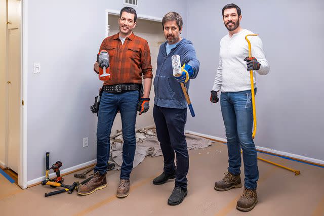 <p>HGTV</p> Drew and Jonathan Scott pose with Ray Romano during the renovation process.