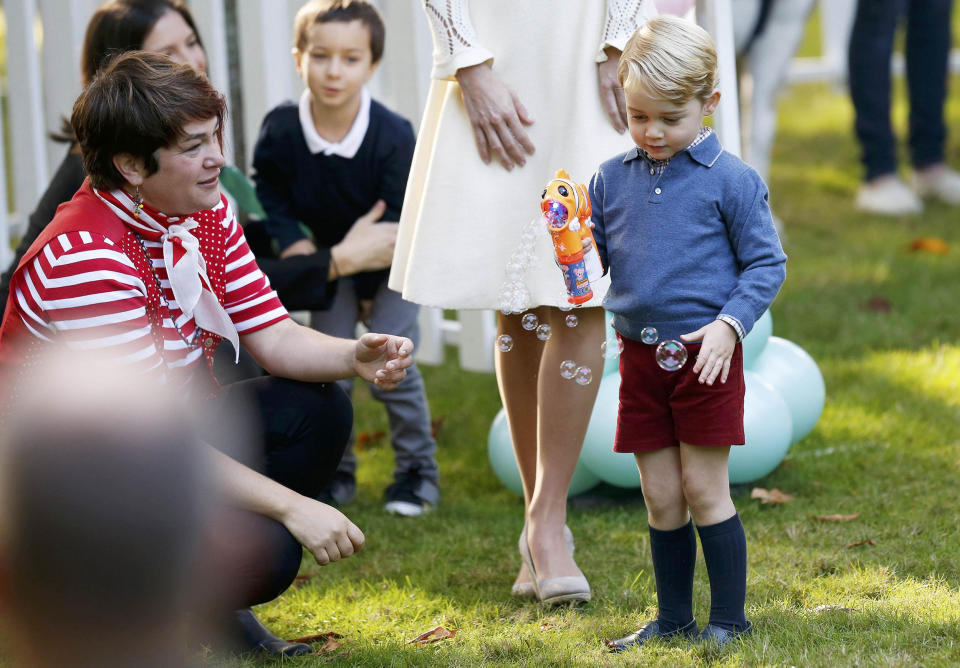 Prince George plays with a bubble gun at a children's party at Government House in Victoria (Chris Wattie / Reuters)