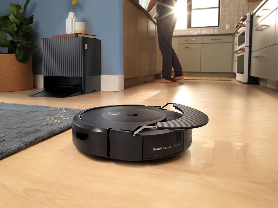 A Roomba on the kitchen floor.