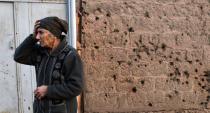 An eldery woman reacting next to a wall damaged by a shell in the Armenian village of Movses, close to the border with Azerbaijan, on February 16, 2015