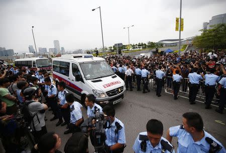 Police vehicles drive into the offices of Hong Kong's Chief Executive Leung Chun-ying after protester block the only available entrance last night, October 2, 2014. REUTERS/Carlos Barria