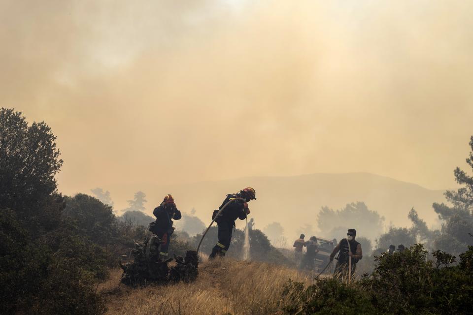 Firefighters operate during a wildfire in Vati village, on the Aegean Sea island of Rhodes, southeastern Greece, on Tuesday, July 25, 2023. A third successive heat wave in Greece pushed temperatures back above 40 degrees Celsius (104 degrees Fahrenheit) across parts of the country Tuesday following more nighttime evacuations from fires that have raged out of control for days. (AP Photo/Petros Giannakouris)