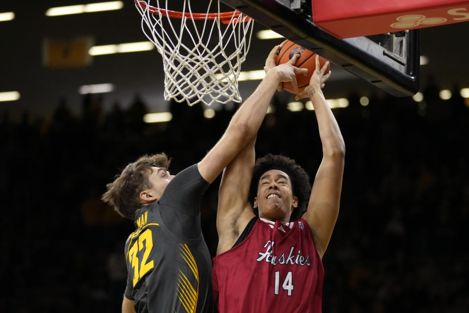 Iowa forward Owen Freeman (32) blocks a shot by Northern Illinois forward Yanic Konan Niederhauser (14) during the first half of an NCAA college basketball game Friday, Dec. 29, 2023, in Iowa City, Iowa. (AP Photo/Charlie Neibergall)