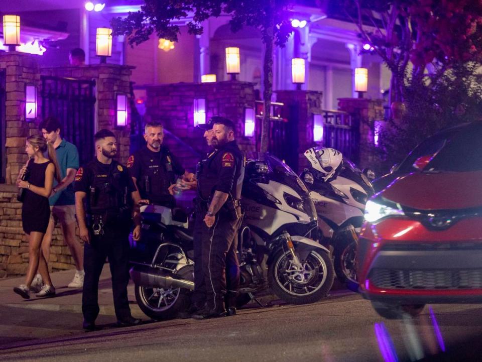 As midnight approaches four Raleigh Police Department motorcycle officers gather at the corner of Glenwood Avenue and Johnson Streets on Friday July 21, 2023 in Raleigh, N.C.