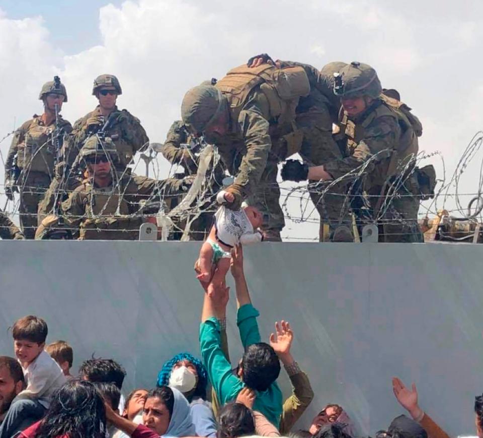 In this image from video provided by Omar Haidari and taken on Thursday, Aug. 19, 2021, which shows a baby being lifted across a wall at Kabul Airport in Afghanistan by U.S. soldiers. The image grabbed from footage, taken on Thursday, showed the infant being pushed up to the soldiers by people in the crowd gathered outside the airport, amid the chaos of those fleeing the Taliban takeover of the country.
