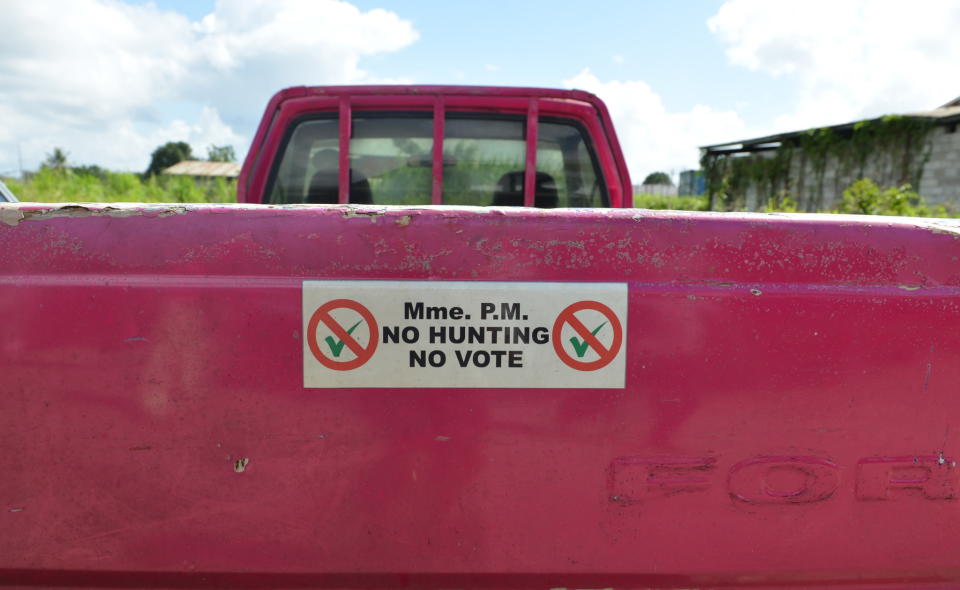In this Dec. 31, 2013 photo, a bumper sticker, produced by a hunters' group that is against the hunting ban, adorns the tailgate of a pick-up truck, parked in Chaguanas, Trinidad. The twin-island country’s government, at least on paper, has transformed the Caribbean nation into a no-trapping, no-hunting zone for about two years to give overexploited game animals some breathing room and to conduct wildlife surveys. Some 13,000 licensed hunters and their trained hounds are now forbidden to hunt on state lands. (AP Photo/David McFadden)