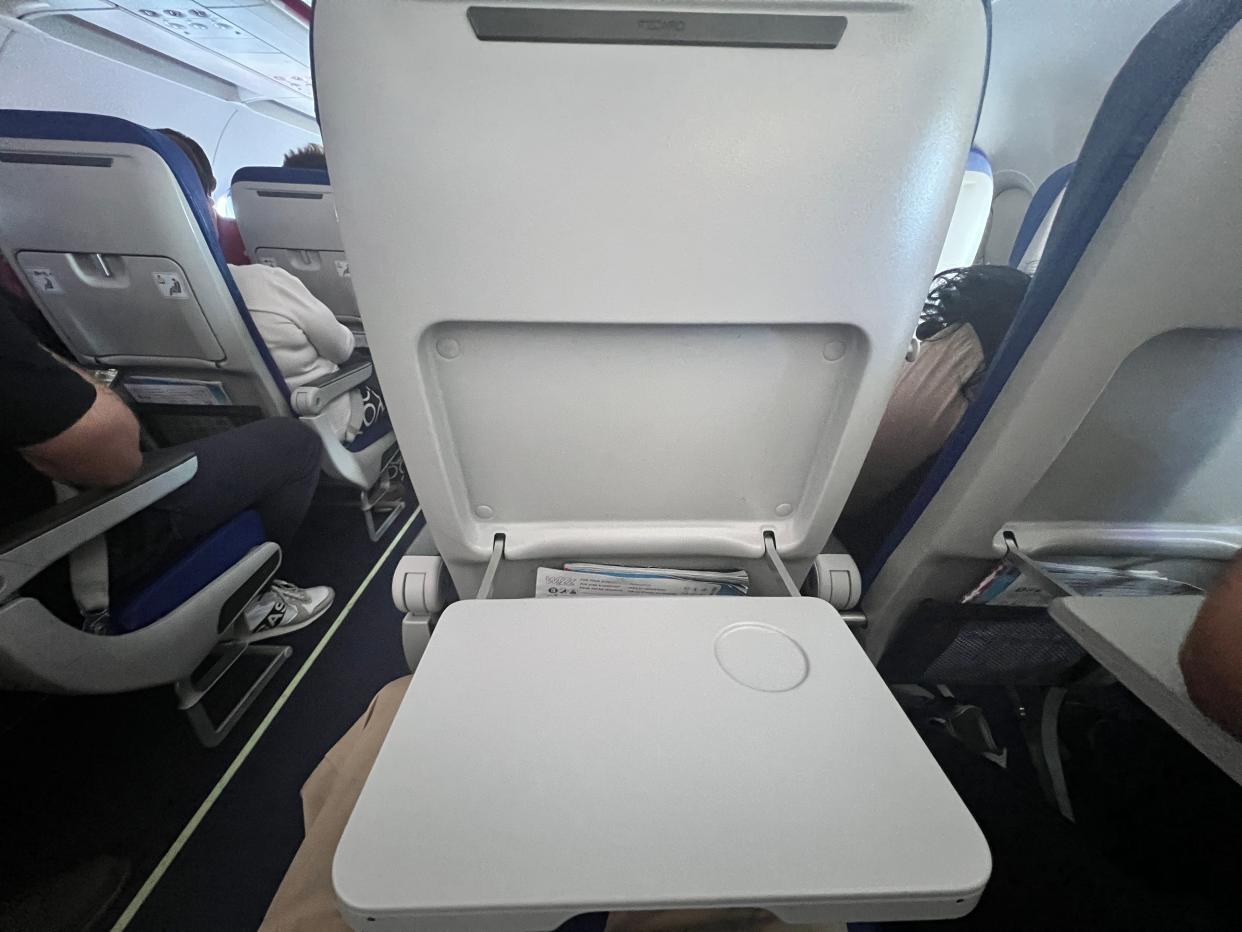 The back of a seat on board a Wizz Air Airbus A321neo with the tray table down.