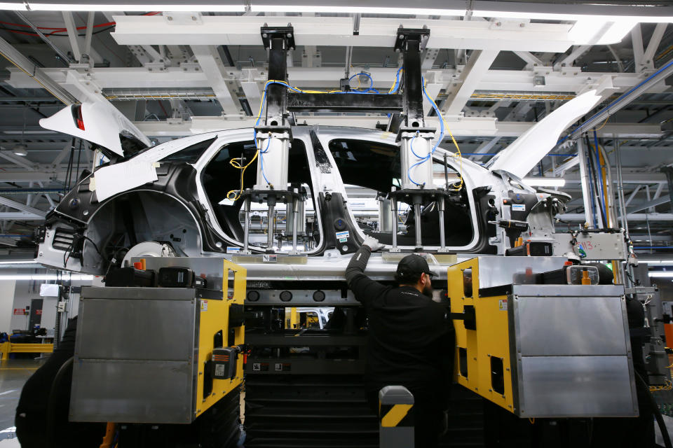 Workers marry the body structure with the battery pack and the front and rear sub frames as they assemble electric vehicles at the Lucid Motors plant in Casa Grande, Arizona, U.S. September 28, 2021.  REUTERS/Caitlin O'Hara/File Photo