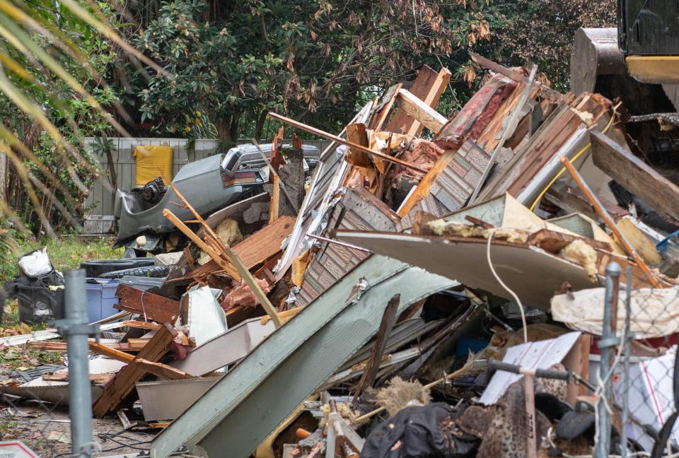 Workers remove debris after demolishing the abandoned house at 1104 North V Street in Pensacola on Tuesday, Nov. 14, 2023. Homeless squatters have been living in the dilapidated house and causing problems for neighbors.