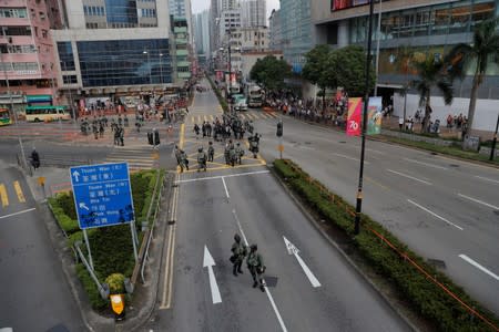 Riot police officers block the road in Tsuen Wan, near the site where police shot a protester with live ammunition on China's National Day in Hong Kong