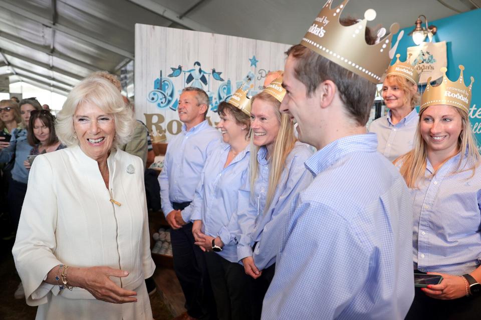 Camilla, Duchess of Cornwall laughs with exhibitors from Rodda's Cornish Clotted Cream as she attends the Royal Cornwall Show at The Royal Cornwall Showground
