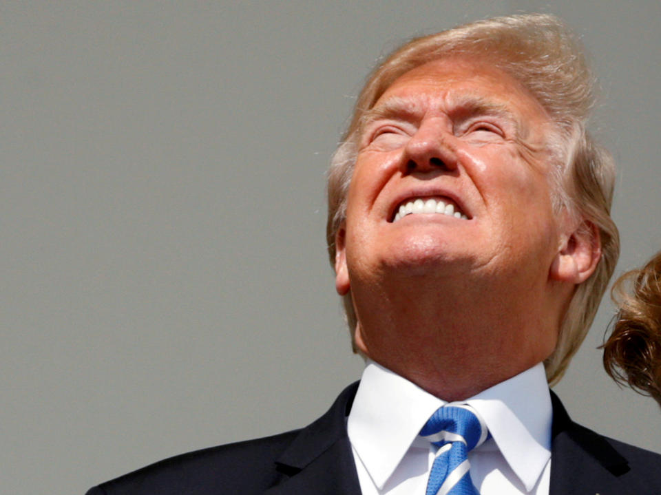 President Donald Trump looks toward the solar eclipse without his protective glasses from the Truman balcony of the White House. (Photo: Kevin Lamarque / Reuters)