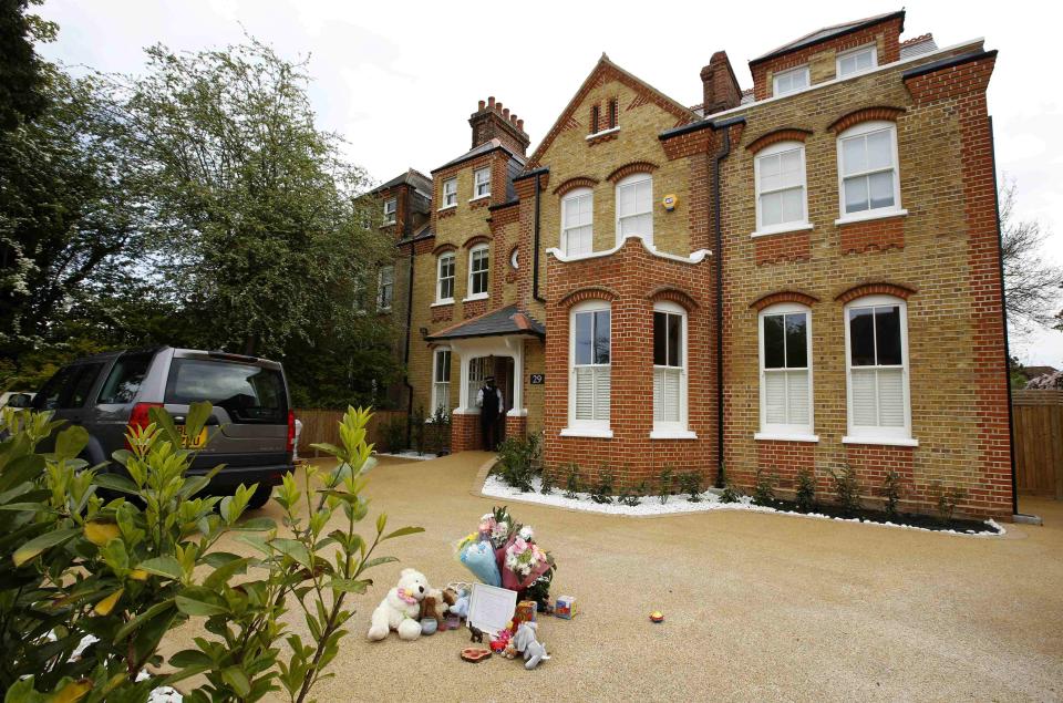 Flowers and toys are seen outside a house where the bodies of three children were found, in New Malden, southwest London April 23, 2014. A 43-year-old woman has been arrested on suspicion on murder after the bodies of three children were found at a house in southwest London, police said on Wednesday. Police said a four-year-old girl and two boys, both aged three, were found dead at a residential address in New Malden on Tuesday evening. REUTERS/Olivia Harris (BRITAIN - Tags: CRIME LAW SOCIETY)