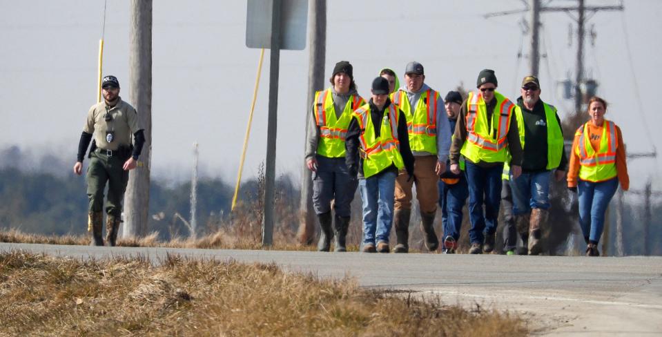 Police and area firefighters walk along state Highway 310 near Johnston Drive during the search for missing 3-year-old Elijah Vue on Feb. 27 in Two Rivers.