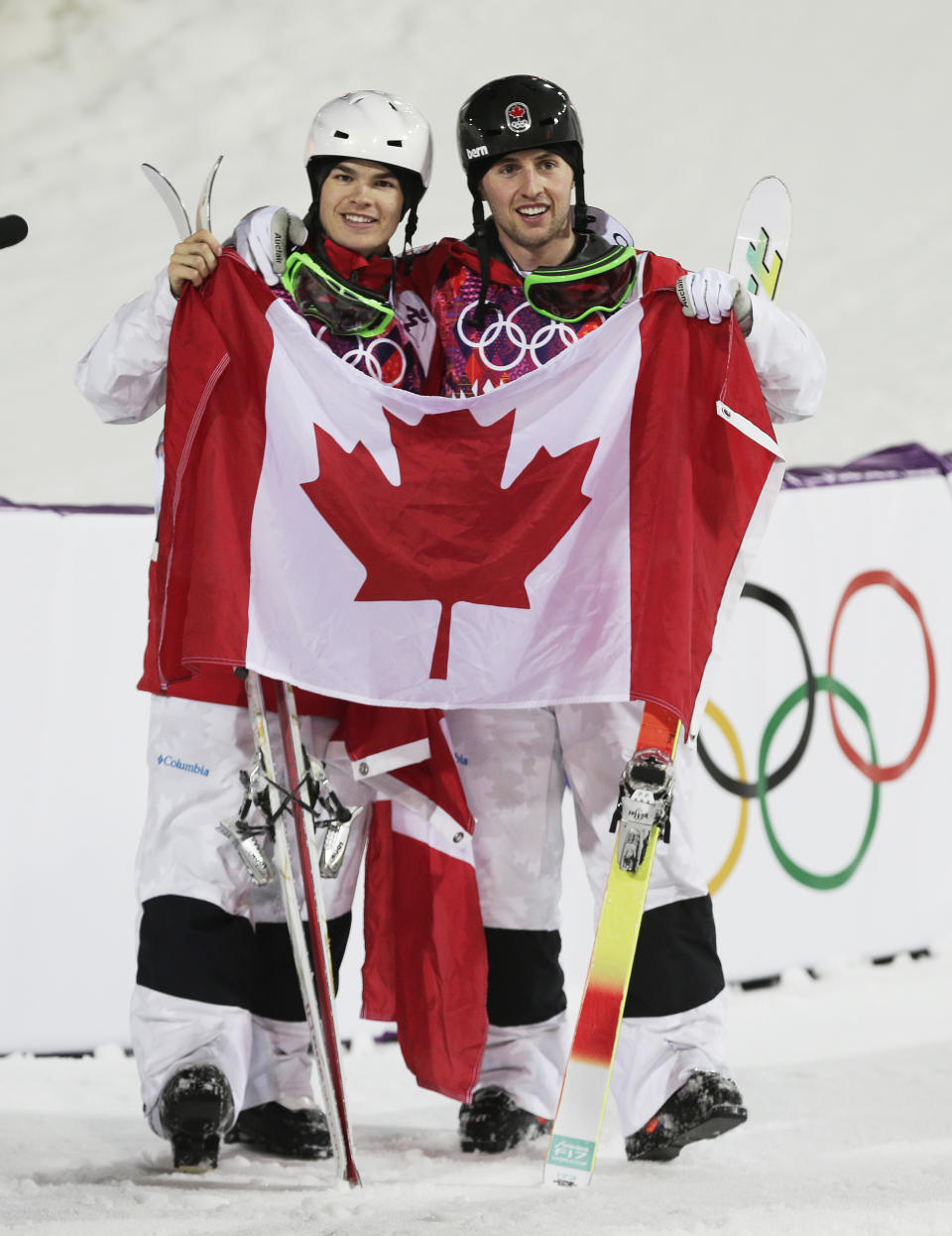 Canada's Alex Bilodeau, right, celebrates with compatriot Mikael Kingsbury after after Bilodeau won gold and Kingsbury took silver in the men's moguls final at the Rosa Khutor Extreme Park at the 2014 Winter Olympics, Monday, Feb. 10, 2014, in Krasnaya Polyana, Russia. (AP Photo/Andy Wong)