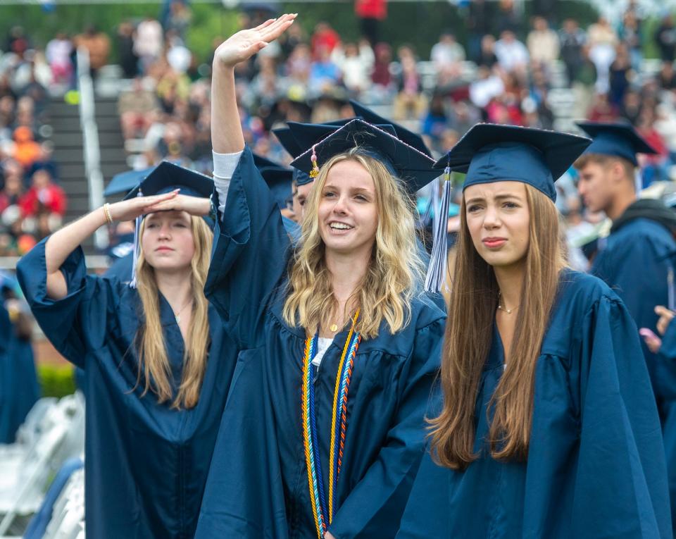 Framingham High School graduates, from left, Molly Clark, Amelia Coates and Caroline Cohen, look for family and friends during Sunday's graduation ceremony at Bowditch Field, June 4, 2023.