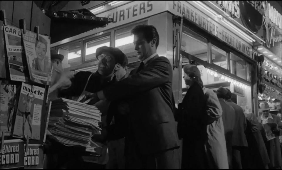 Sidney Falco desperately searches the papers for items he's attempted to place in Sweet Smell of Success.