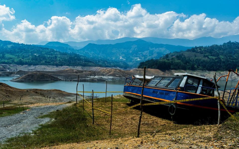 A boat rests on a dry section of the Guavio reservoir that feeds a hydroelectric power plant in Gachala