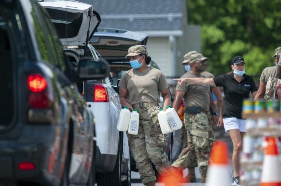 U.S. Army Pfc. Krystal Rivera, a motor transport operator with the Delaware Army National Guard’s 1049th Transportation Company, handles jugs of milk during a drive-thru mobile pantry at Woodbridge High School in Greenwood on June 22.