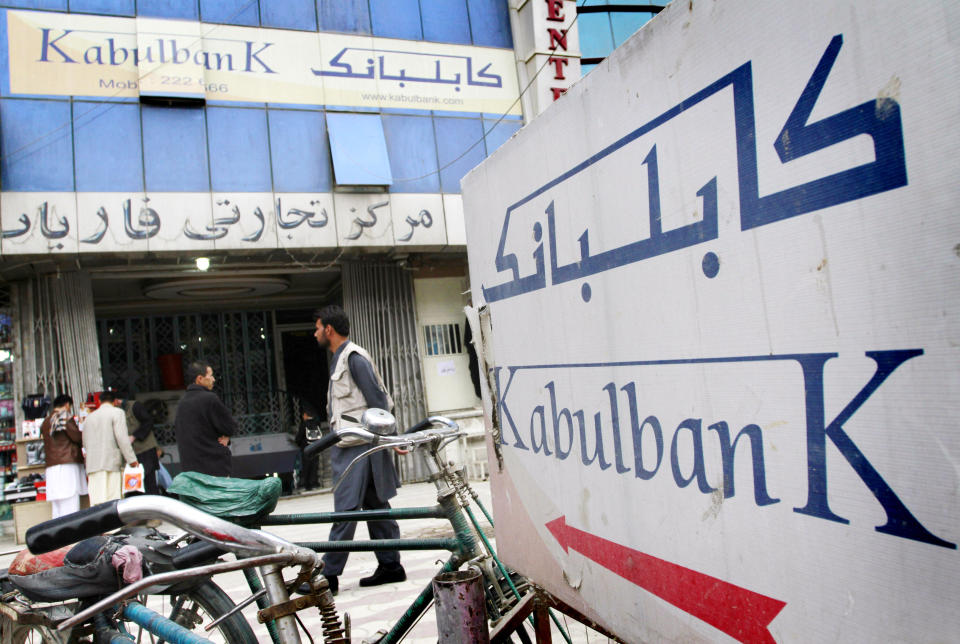 FILE- In this March 27, 2011, file photo, an Afghan man walks past by a branch of Kabul Bank in Kabul, Afghanistan. An independent Afghan financial commission has been asked to recommend whether to dissolve Kabul Bank, the nation's largest financial institution that nearly collapsed last year after allegations of mismanagement, cronyism and questionable lending, an Afghan official said Sunday. (AP Photo/Musadeq Sadeq, File)