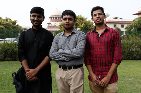 Anwesh Pokkuluri, Romel Barel and Krishna Reddy M, petitioners challenging Section 377 of the Indian Penal Code that criminalises homosexuality, pose outside the premises of the Supreme Court in New Delhi, July 10, 2018. REUTERS/Adnan Abidi/Files