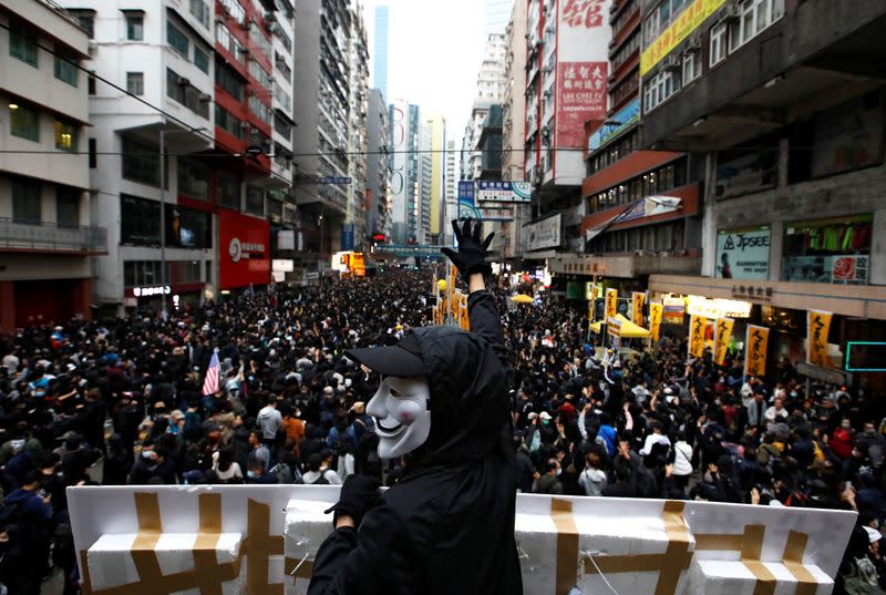 An anti-government protester wearing a Guy Fawkes mask takes part in a demonstration during New Year's Day to call for better governance and democratic reforms in Hong Kong