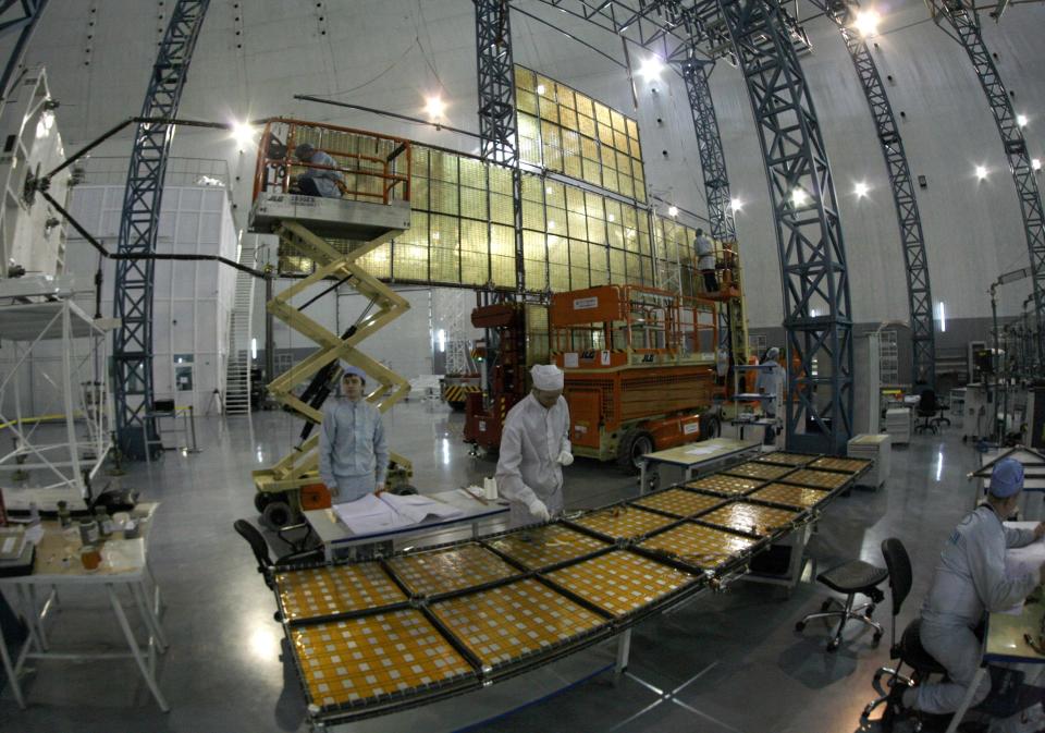 Specialists of the "Kvant" (Quantum) research-and-production enterprise work on a solar battery for the Express AM6 new generation geostationary telecommunications heavy satellite at the large-sized transformed mechanical systems centre of the Reshetnev Information Satellite Systems company in the Siberian town of Zheleznogorsk, some 50 km (31 miles) northeast of Krasnoyarsk, April 2, 2014. The Express AM6 is a new generation satellite providing services including Russian governmental and presidential mobile communication, digital television and broadcasting, according to the Reshetnev company representatives. Picture taken April 2, 2014. REUTERS/Ilya Naymushin (RUSSIA - Tags: SCIENCE TECHNOLOGY BUSINESS TELECOMS)