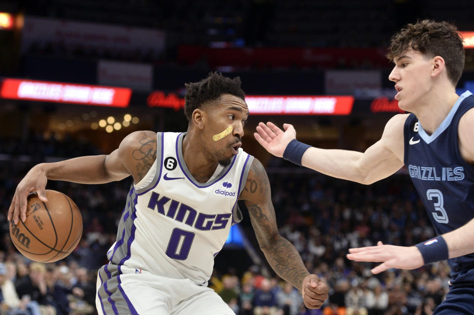 Sacramento Kings guard Malik Monk (0) handles the ball against Memphis Grizzlies forward Jake LaRavia (3) in the second half of an NBA basketball game, Tuesday, Nov. 22, 2022, in Memphis, Tenn. (AP Photo/Brandon Dill)