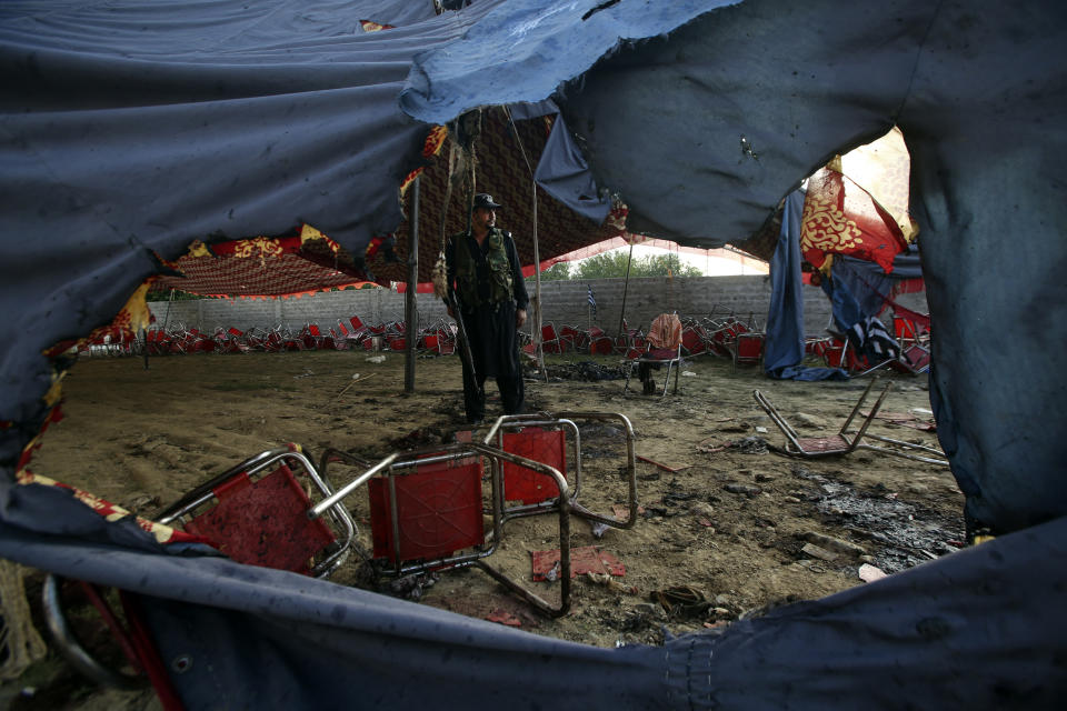 A Pakistani police officer stand guard at the site of Sunday's suicide bomber attack in the Bajur district of Khyber Pakhtunkhwa, Pakistan, Monday, July 31, 2023. A suicide bomber blew himself up at a political rally in a former stronghold of militants in northwest Pakistan bordering Afghanistan on Sunday, killing and wounding multiple people in an attack that a senior leader said was meant to weaken Pakistani Islamists. (AP Photo/Mohammad Sajjad)