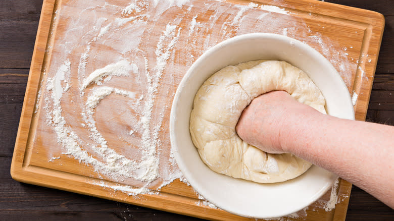 Person punching down dough