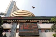 FILE PHOTO: A bird flies past a screen displaying the Sensex results on the facade of BSE building in Mumbai, India