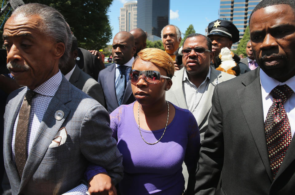 ST. LOUIS, MO - AUGUST 12:  Lesley McSpadden (C), the mother of slain teenager Michael Brown, arrives for a press conference on the arm of civil rights leader Rev. Al Sharpton (L) on August 12, 2014 in St. Louis, Missouri. Brown was shot and killed by a police officer on Saturday in suburban Ferguson, Missouri. Sharpton and Browns family were calling for order following riots and skirmishes with police over the past two nights in Ferguson by demonstrators angry over the shooting.  (Photo by Scott Olson/Getty Images)