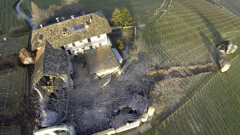 In this photo provided by Tareom.com Thursday, Jan. 30, 2014, and taken on Jan. 23, 2014, a huge boulder is seen after it missed a farm house by less than a meter, destroying the barn, and stopped in the vineyard, while the second giant boulder at left, which detached during the same landslide on Jan. 21, 2014, stopped next to the house, in Ronchi di Termeno, in Northern Italy. According to reports, the Trebo family living there was unharmed in the landslide. (AP Photo/Markus Hell, Tareom.com, ho)