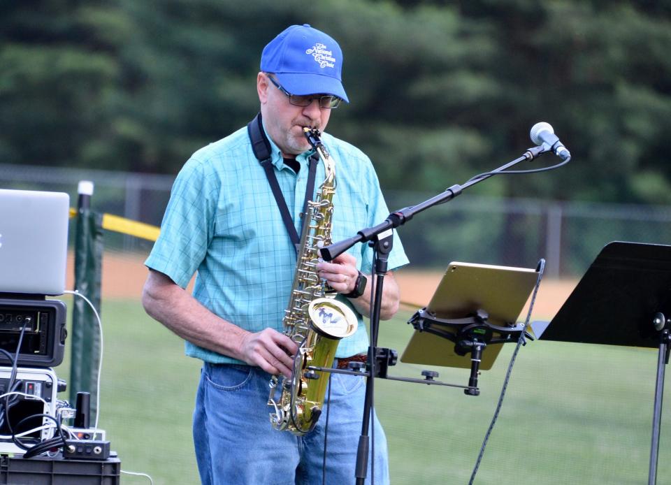 Smithsburg resident Bryan Wiles performs "Amazing Grace, My Chains Are Gone" on a synthaphone, or midi sax, Saturday night during a vigil at Lions Community Park for victims of the June 9 shooting at nearby Columbia Machine.